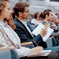 © albertyurolaits | magnific.com | Business seminar participants taking notes in their notebooks