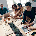 © gstockstudio | magnific.com | Sich um das Geschäft kümmern. Draufsicht auf junge moderne Menschen in smarter Freizeitkleidung mit modernen Technologien bei der Arbeit im Kreativbüro