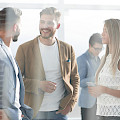 © ASDFpik | magnific.com | Hinter der Glasscheibe stehen junge Mitarbeiter im Büro